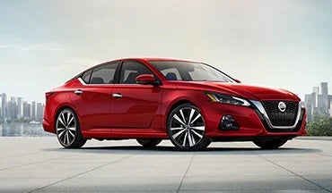 2023 Nissan Altima in red with city in background illustrating last year's 2022 model in Ken Ganley Nissan Mayfield in Mayfield Heights OH