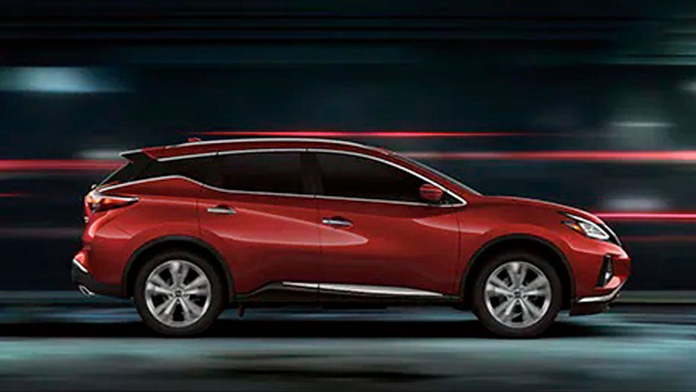 2023 Nissan Murano shown in profile driving down a street at night illustrating performance. | Ken Ganley Nissan Mayfield in Mayfield Heights OH