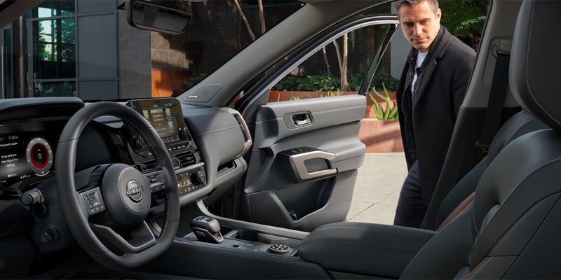 A passenger climbing into the 2025 Nissan Pathfinder in Mayfield Heights, OH